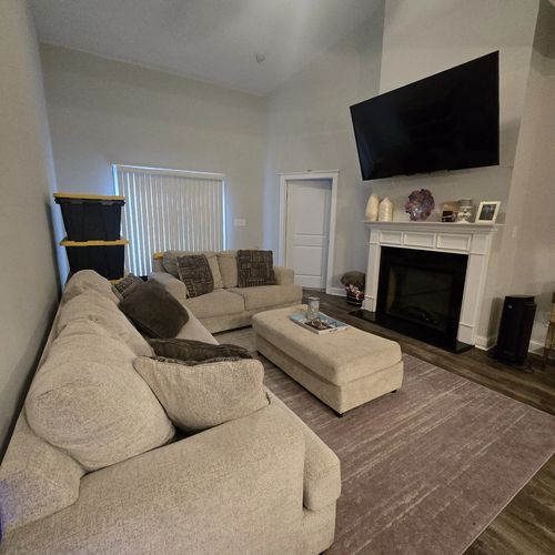 Furnished living room with cathedral ceilings, sectional sofa and electric fireplace